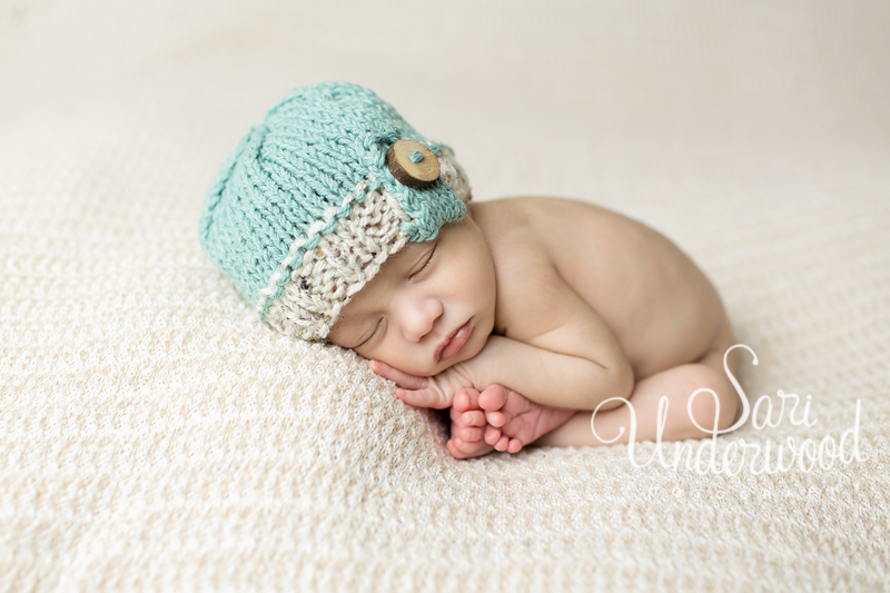 newborn baby boy posed with his little toes peeking out