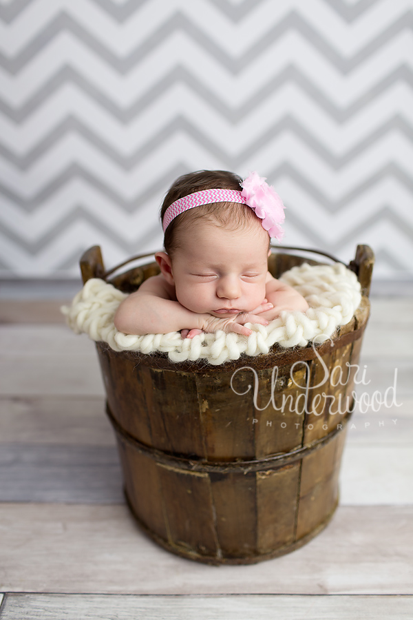 newborn baby girl posed in a vintage bucket